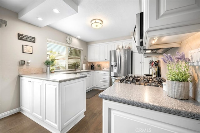 6898 Breton Way, Cypress, CA 90630 - kitchen featuring appliances with stainless steel finishes, a peninsula, white cabinetry, dark wood-style floors, and recessed lighting