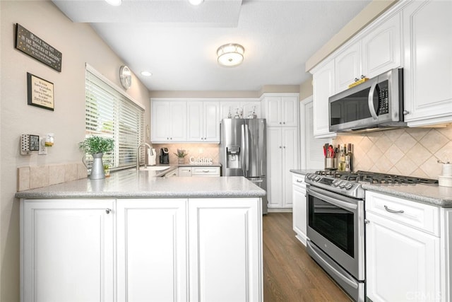 6898 Breton Way, Cypress, CA 90630 - kitchen with stainless steel appliances, a peninsula, white cabinets, and dark wood-style floors