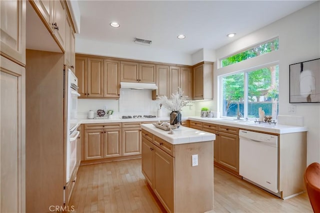 30 Oakhurst Rd, Irvine, CA 92620 - kitchen with white appliances, a sink, tile counters, under cabinet range hood, and light wood-type flooring