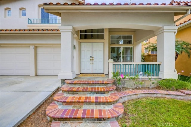 30 Oakhurst Rd, Irvine, CA 92620 - doorway to property featuring a tiled roof, stucco siding, concrete driveway, covered porch, and a garage