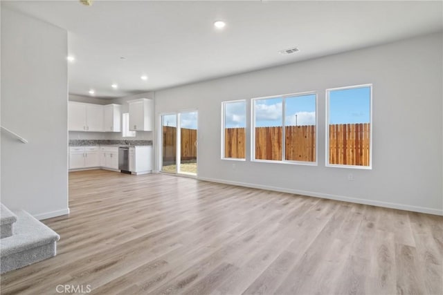 68 Sedona Dr, Merced, CA 95341 - unfurnished living room featuring recessed lighting, light wood-style floors, baseboards, and stairs