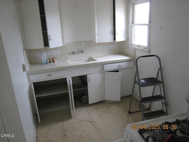 542 1st St, Fillmore, CA 93015 - kitchen featuring a sink, white cabinetry, tasteful backsplash, and tile counters