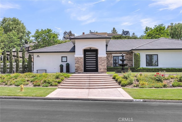 30195 Corte Coelho, Temecula, CA 92591 - view of front of home with stucco siding, stone siding, a tiled roof, and a front lawn