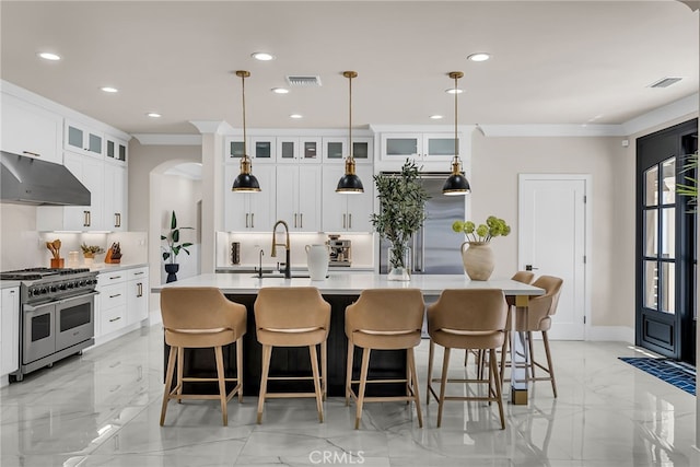 30195 Corte Coelho, Temecula, CA 92591 - kitchen with under cabinet range hood, high end appliances, a kitchen island with sink, backsplash, and light countertops