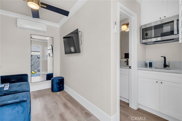 30195 Corte Coelho, Temecula, CA 92591 - corridor featuring light wood-style floors, a wall mounted AC, a sink, and baseboards