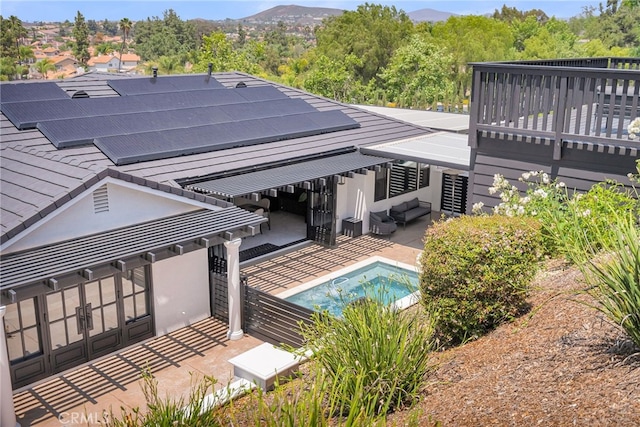 30195 Corte Coelho, Temecula, CA 92591 - rear view of property featuring roof mounted solar panels, a patio area, outdoor lounge area, an outdoor pool, and stucco siding