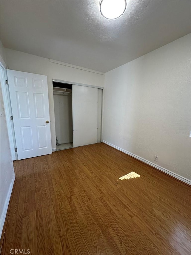 942 E 6th St, Pomona, CA 91766 - unfurnished bedroom featuring wood finished floors and a closet