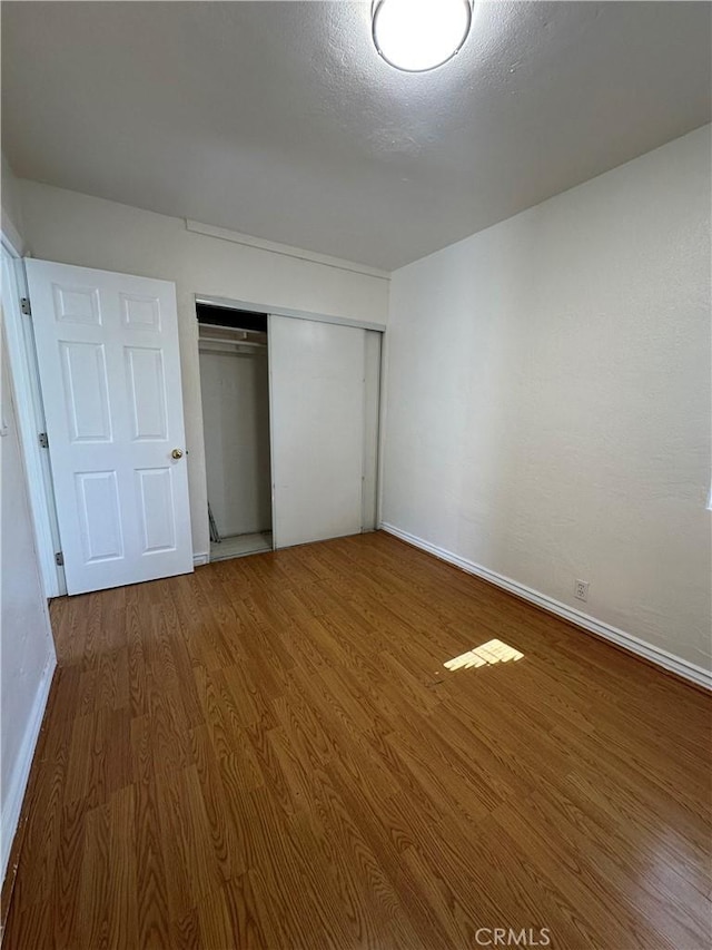 942 E 6th St, Pomona, CA 91766 - unfurnished bedroom with wood finished floors and a closet