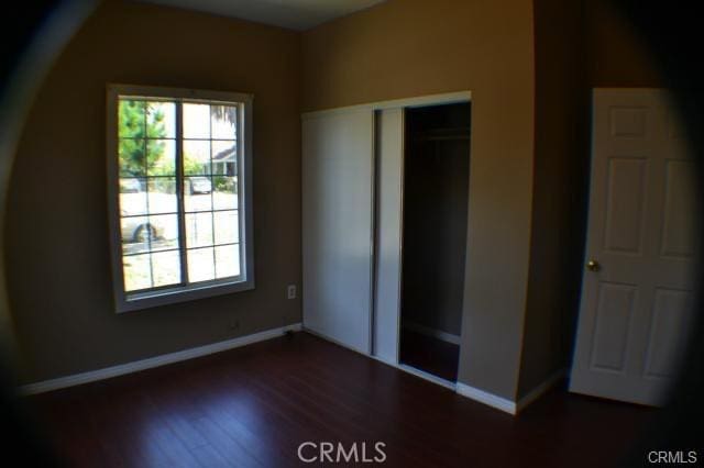 942 E 6th St, Pomona, CA 91766 - unfurnished bedroom featuring dark wood-style floors and a closet