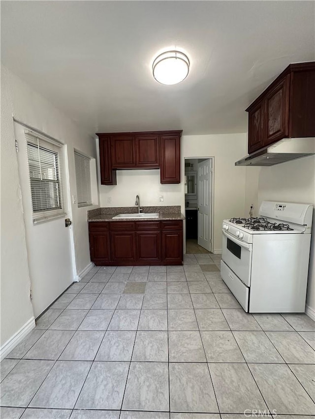 942 E 6th St, Pomona, CA 91766 - kitchen featuring white gas stove, under cabinet range hood, and light tile patterned floors