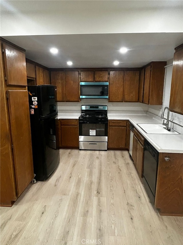 10309 Bodger St Unit 14, El Monte, CA 91733 - kitchen with black appliances, a sink, light wood-type flooring, and light countertops