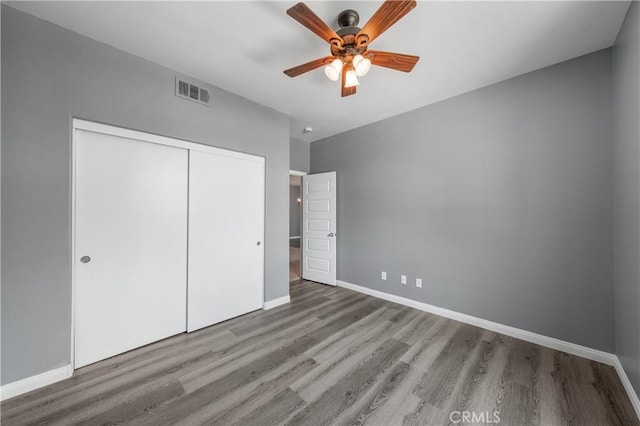 30574 Saddlehorn Way, Menifee, CA 92584 - unfurnished bedroom with wood finished floors, a closet, and a ceiling fan