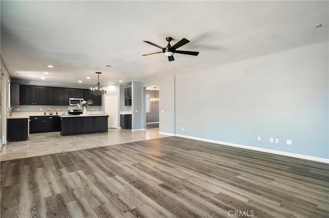 30574 Saddlehorn Way, Menifee, CA 92584 - unfurnished living room featuring a chandelier, light wood finished floors, ceiling fan, and recessed lighting