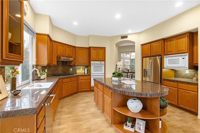 221 Grand Oaks Dr, Glendora, CA 91741 - kitchen featuring stainless steel appliances, open shelves, a sink, under cabinet range hood, and arched walkways
