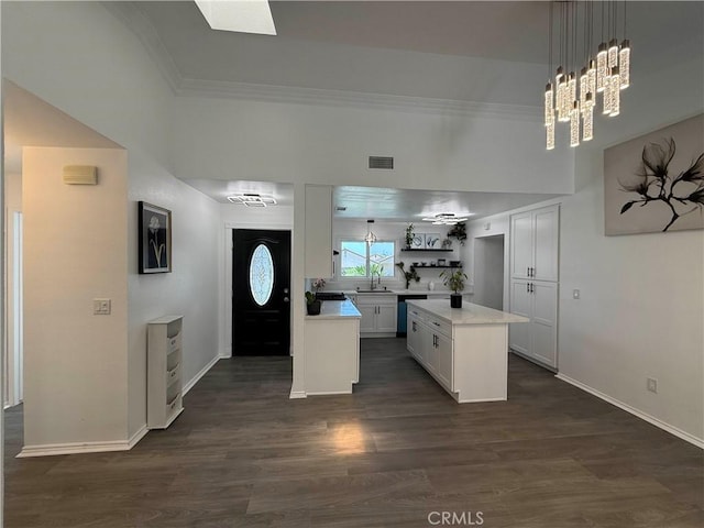 10328 Shoshone Ave, Riverside, CA 92503 - kitchen with a sink, light countertops, dark wood-style floors, a center island, and crown molding
