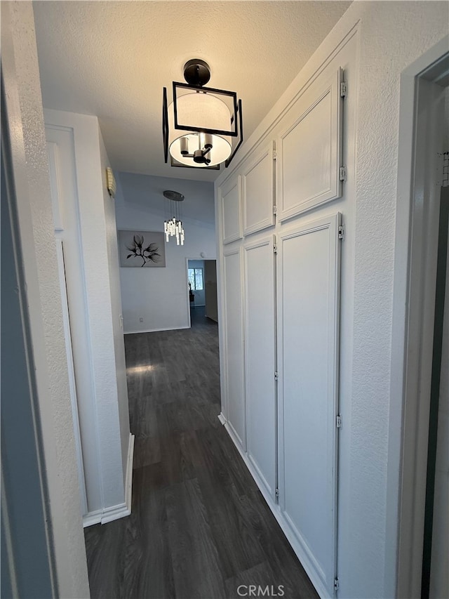 10328 Shoshone Ave, Riverside, CA 92503 - hallway featuring dark wood-style floors, a chandelier, and baseboards