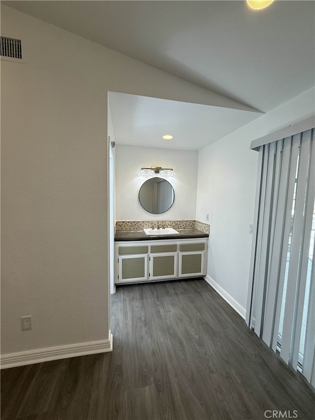 10328 Shoshone Ave, Riverside, CA 92503 - hallway featuring dark wood-type flooring, a sink, baseboards, and vaulted ceiling
