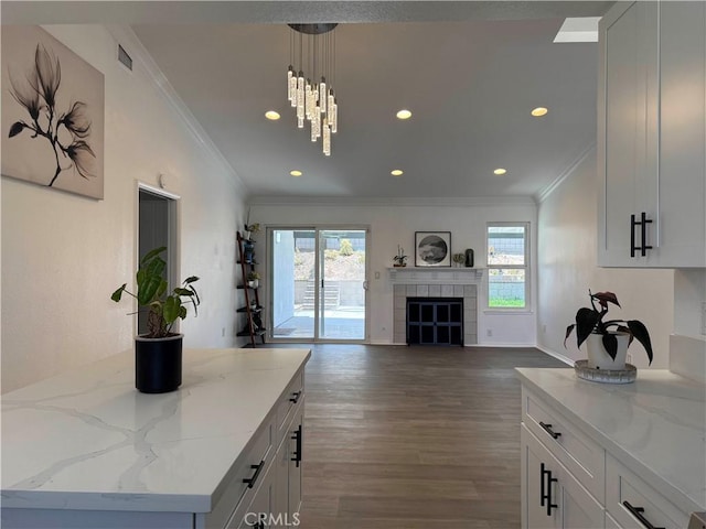 10328 Shoshone Ave, Riverside, CA 92503 - kitchen with ornamental molding, dark wood-style flooring, recessed lighting, white cabinetry, and light stone countertops