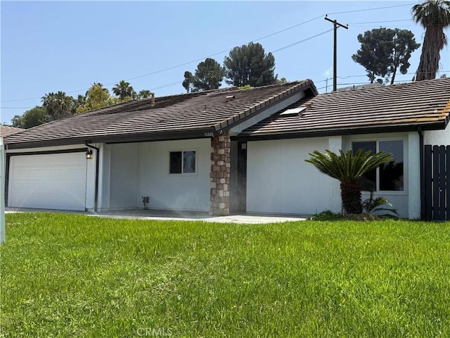 10328 Shoshone Ave, Riverside, CA 92503 - back of property with an attached garage, a tiled roof, a lawn, and stucco siding