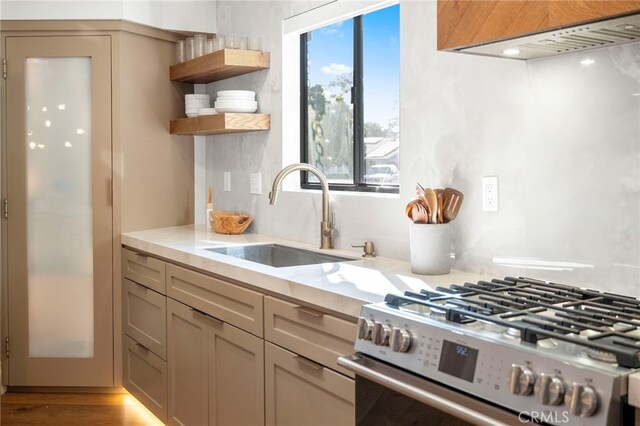 3066 Claret Cir, Atwater, CA 95301 - kitchen with stainless steel gas range oven, a sink, extractor fan, light countertops, and open shelves