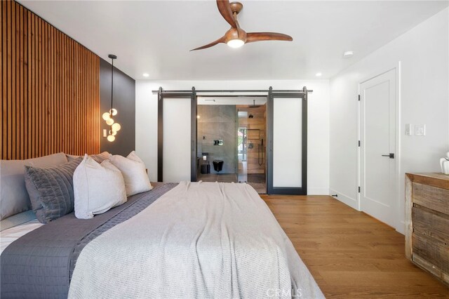 3066 Claret Cir, Atwater, CA 95301 - bedroom with a barn door, wood finished floors, a ceiling fan, and recessed lighting