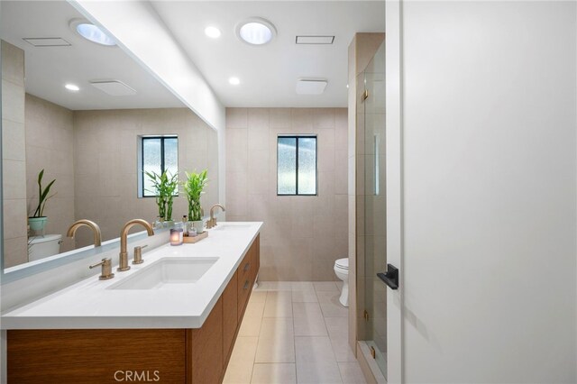 3066 Claret Cir, Atwater, CA 95301 - full bathroom with toilet, healthy amount of natural light, double vanity, tile patterned flooring, and tile walls