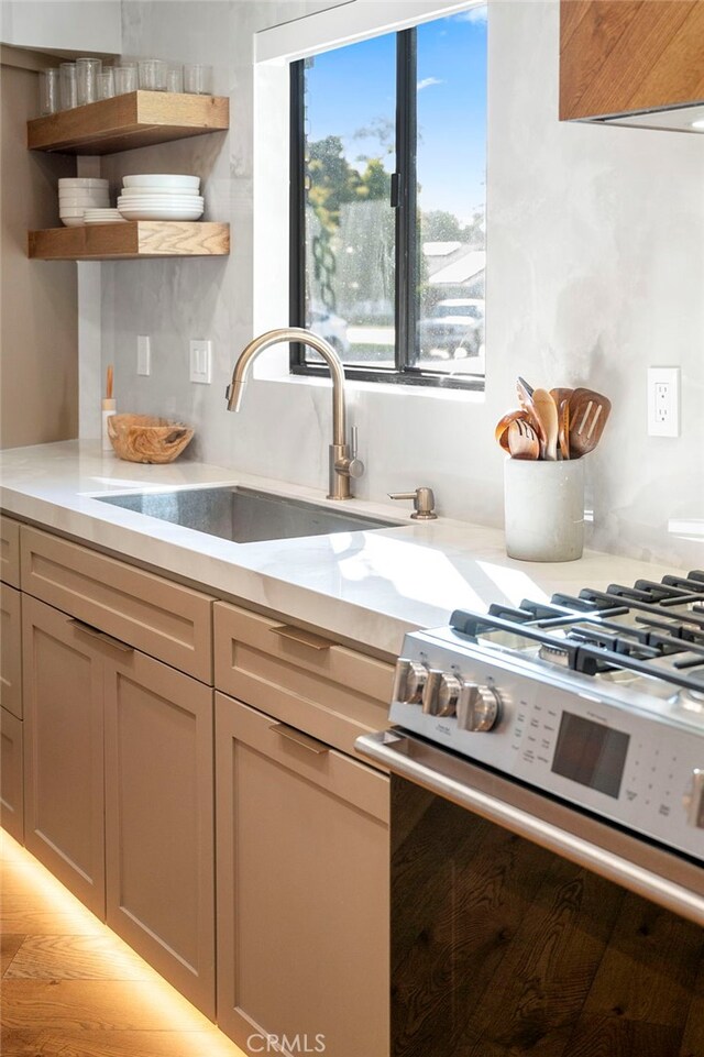 3066 Claret Cir, Atwater, CA 95301 - kitchen with stainless steel gas range oven, open shelves, and a sink