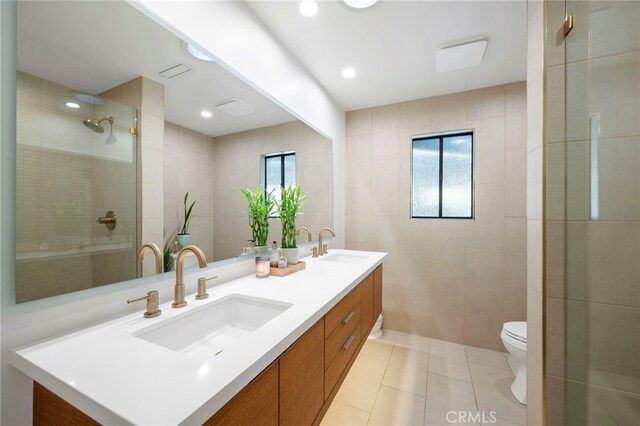 3066 Claret Cir, Atwater, CA 95301 - full bathroom with toilet, double vanity, tile patterned flooring, tiled shower, and tile walls