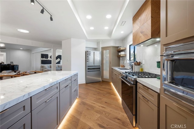 3066 Claret Cir, Atwater, CA 95301 - kitchen with stainless steel appliances, a sink, wall chimney exhaust hood, light wood-style flooring, and gray cabinets