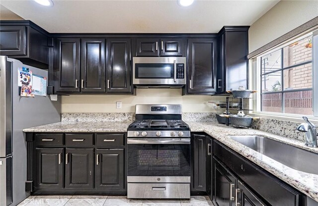 9791 Lee St, Cypress, CA 90630 - kitchen with stainless steel appliances, a sink, dark cabinets, light stone counters, and recessed lighting