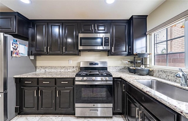 9791 Lee St, Cypress, CA 90630 - kitchen featuring stainless steel appliances, a sink, dark cabinets, light stone counters, and recessed lighting