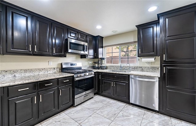 9791 Lee St, Cypress, CA 90630 - kitchen with stainless steel appliances, a sink, dark cabinets, light marble finish flooring, and recessed lighting