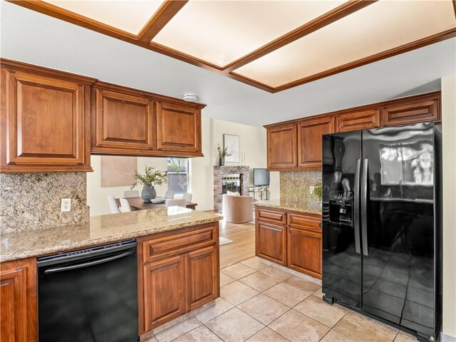 1523 E Pryor Dr, Fresno, CA 93720 - kitchen with black appliances, backsplash, brown cabinets, a fireplace, and light stone countertops
