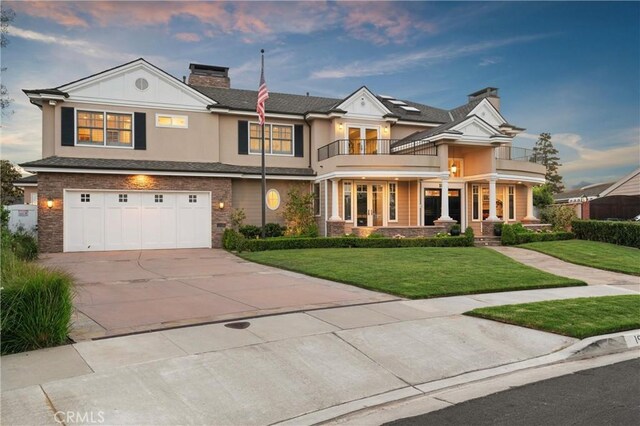 1921 Windward Ln, Newport Beach, CA 92660 - view of front facade featuring a balcony, a chimney, a lawn, concrete driveway, and a garage