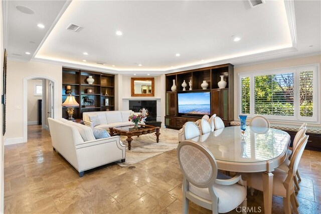 1921 Windward Ln, Newport Beach, CA 92660 - living room with a tray ceiling, recessed lighting, arched walkways, baseboards, and light stone finish flooring