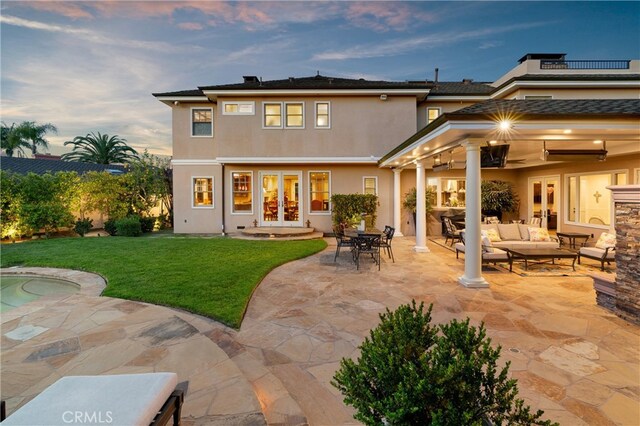 1921 Windward Ln, Newport Beach, CA 92660 - back of property at dusk featuring french doors, outdoor lounge area, stucco siding, a yard, and a patio area