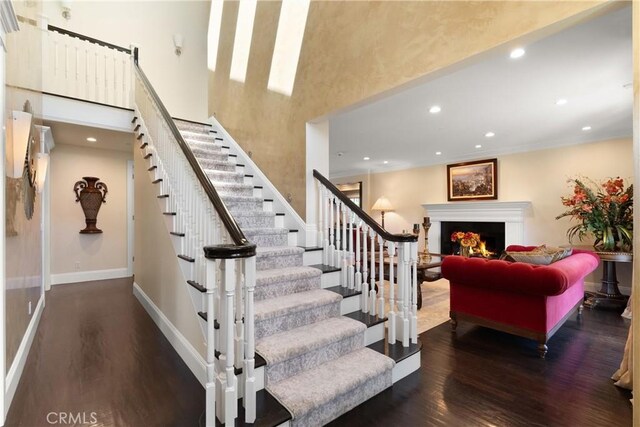 1921 Windward Ln, Newport Beach, CA 92660 - stairs featuring wood finished floors, a lit fireplace, recessed lighting, baseboards, and a high ceiling
