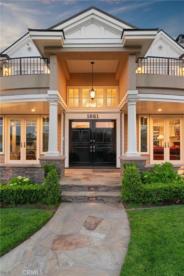 1921 Windward Ln, Newport Beach, CA 92660 - view of exterior entry with french doors, a balcony, and stone siding