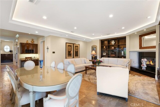 1921 Windward Ln, Newport Beach, CA 92660 - dining space featuring a tray ceiling, a warm lit fireplace, recessed lighting, and crown molding