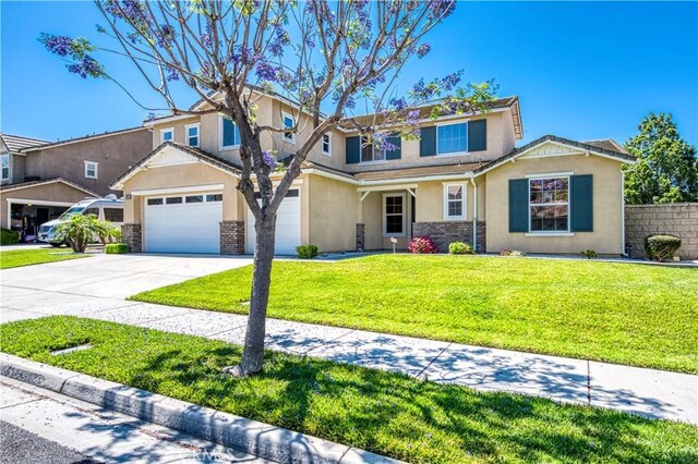 14939 Franklin Ln, Eastvale, CA 92880 - view of front facade with stucco siding, driveway, and stone siding