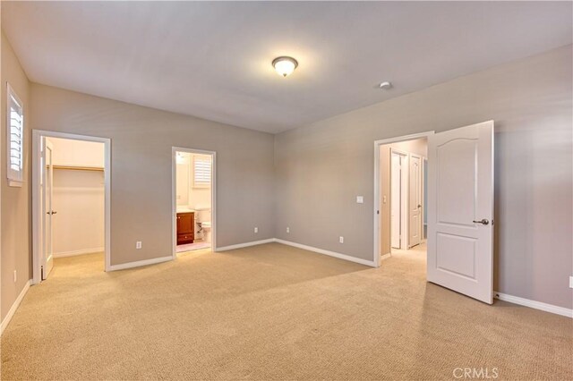 14939 Franklin Ln, Eastvale, CA 92880 - unfurnished bedroom with light carpet, a walk in closet, and ensuite bath