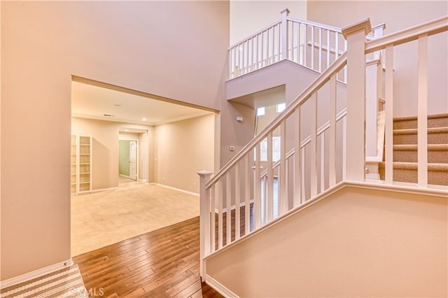 14939 Franklin Ln, Eastvale, CA 92880 - stairway featuring hardwood / wood-style flooring, carpet flooring, and a towering ceiling