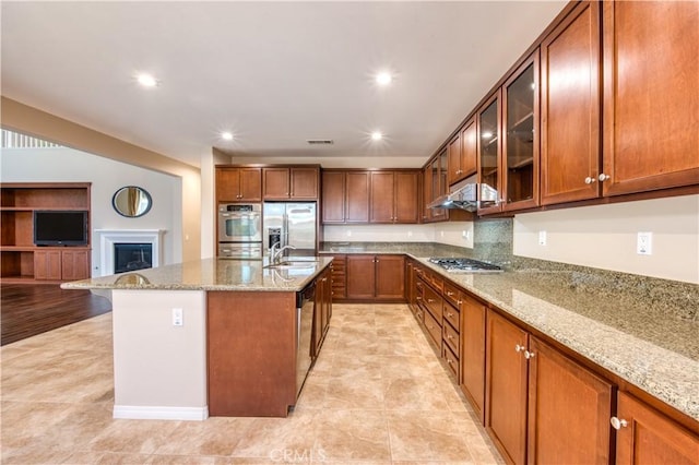 14939 Franklin Ln, Eastvale, CA 92880 - kitchen with stainless steel appliances, light stone counters, brown cabinets, glass insert cabinets, and recessed lighting