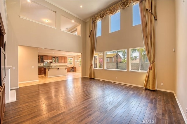 14939 Franklin Ln, Eastvale, CA 92880 - unfurnished living room with ornamental molding, a high ceiling, and dark wood finished floors