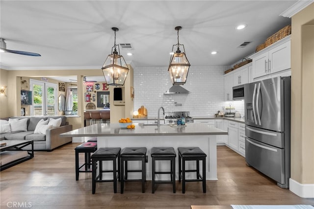 19969 Via Joyce Dr, Saugus, CA 91350 - kitchen with stainless steel appliances, a breakfast bar area, white cabinets, tasteful backsplash, and recessed lighting