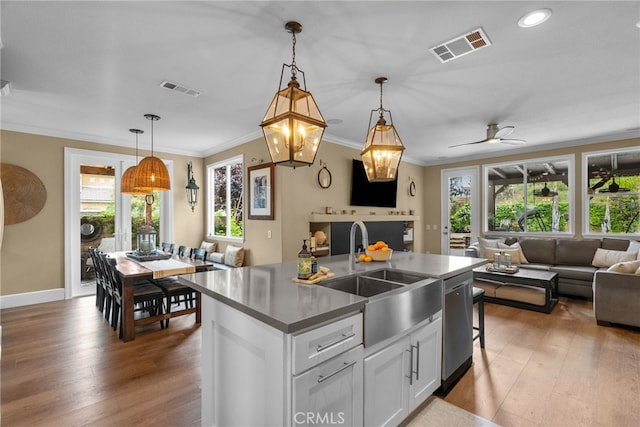 19969 Via Joyce Dr, Saugus, CA 91350 - kitchen with open floor plan, a sink, ornamental molding, a center island with sink, and light wood-style flooring