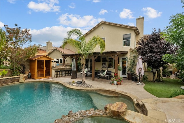 19969 Via Joyce Dr, Saugus, CA 91350 - back of property featuring a patio area, stucco siding, a chimney, and a pool with connected hot tub