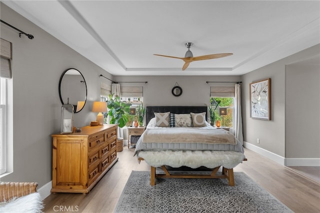 19969 Via Joyce Dr, Saugus, CA 91350 - bedroom with light wood-style flooring, a tray ceiling, and baseboards
