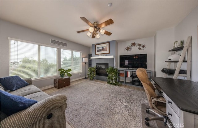29207 Clear Spring Ln, Highland, CA 92346 - living area with ceiling fan, wood finished floors, a desk, baseboards, and a tiled fireplace