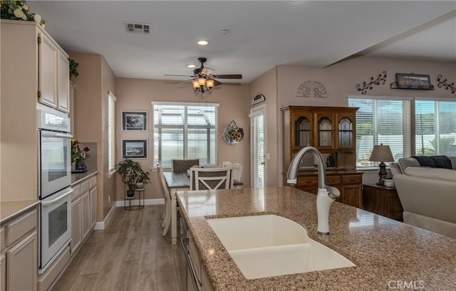 29207 Clear Spring Ln, Highland, CA 92346 - kitchen with a sink, double oven, light wood-style flooring, recessed lighting, and light stone countertops